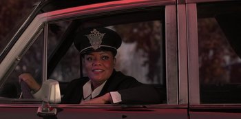 Movie still from “Muppets Haunted Mansion” (2021), directed by Kirk R. Thatcher – A woman sitting in the driver's seat of a car; Medium shot, Over the shoulder angle