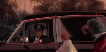Movie still from “Muppets Haunted Mansion” (2021), directed by Kirk R. Thatcher – A woman sitting in the driver's seat of a car; Medium shot, Over the shoulder angle