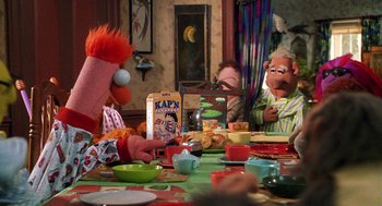 Movie still from “Muppets from Space” (1999), directed by Tim Hill – A group of people sitting around a table; Medium shot, Over the shoulder angle