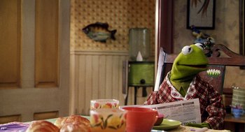 Movie still from “Muppets from Space” (1999), directed by Tim Hill – A person sitting at a table with a cup of coffee; Medium shot, Over the shoulder angle