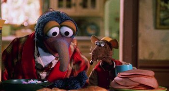 Movie still from “Muppets from Space” (1999), directed by Tim Hill – A couple of stuffed animals sitting on top of a table; Close Up shot, Over the shoulder angle
