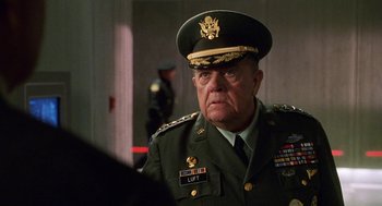 Movie still from “Muppets from Space” (1999), directed by Tim Hill – An older man in a military uniform looking at the camera; Close Up shot, Over the shoulder angle