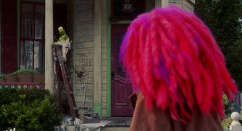 Movie still from “Muppets from Space” (1999), directed by Tim Hill – A person with a pink wig on a ladder; Medium shot, Over the shoulder angle