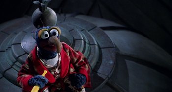 Movie still from “Muppets from Space” (1999), directed by Tim Hill – A stuffed animal wearing a robe; Medium shot, High angle
