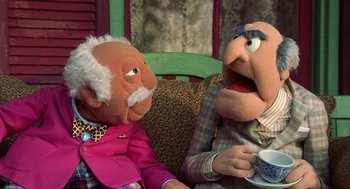 Movie still from “Muppets from Space” (1999), directed by Tim Hill – A couple of puppets sitting next to each other on a couch; Medium shot, Over the shoulder angle