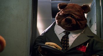 Movie still from “Muppets from Space” (1999), directed by Tim Hill – A man in a suit and tie holding a banana; Medium shot, Low angle
