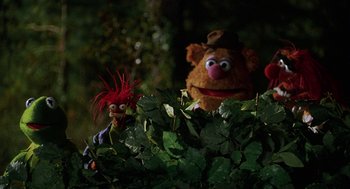 Movie still from “Muppets from Space” (1999), directed by Tim Hill – A couple of stuffed animals sitting on top of a bush; Medium shot, Low angle