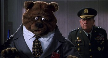 Movie still from “Muppets from Space” (1999), directed by Tim Hill – A man in a suit and tie with a teddy bear head; Close Up shot, Low angle