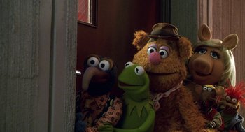 Movie still from “Muppets from Space” (1999), directed by Tim Hill – A group of stuffed animals sitting next to each other in a room; Medium shot, Over the shoulder angle