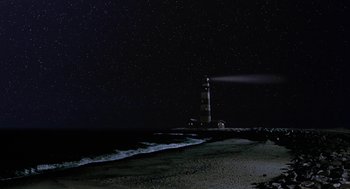 Movie still from “Muppets from Space” (1999), directed by Tim Hill – A lighthouse on the beach at night with the sky in the background; Extreme Wide shot, Low angle