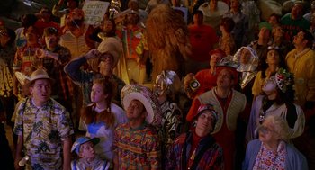 Movie still from “Muppets from Space” (1999), directed by Tim Hill – A group of people wearing costumes in a crowd; Medium shot, High angle
