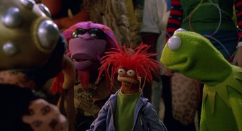 Movie still from “Muppets from Space” (1999), directed by Tim Hill – A group of people standing next to each other in a room; Medium shot, High angle