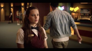 Movie still from “13 Reasons Why” (2017), created by Brian Yorkey – A woman in a red vest and black bow tie; Medium shot, Over the shoulder angle