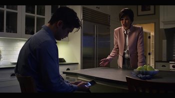 Movie still from “13 Reasons Why” (2017), created by Brian Yorkey – A man and a woman looking at a cell phone; Medium shot, Over the shoulder angle