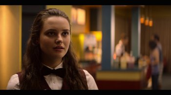 Movie still from “13 Reasons Why” (2017), created by Brian Yorkey – A woman with long brown hair wearing a black bow tie; Close Up shot, Over the shoulder angle