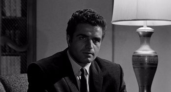 Movie still from “Murder by Contract” (1958), directed by Irving Lerner – Black and white photograph of a man wearing a suit and tie; Close Up shot, Low angle