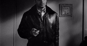 Movie still from “Murder by Contract” (1958), directed by Irving Lerner – A black and white photo of a man smoking a cigarette; Medium shot, High angle