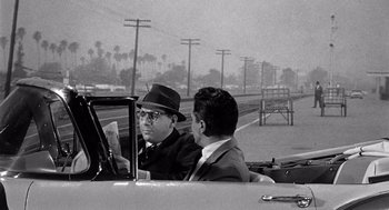 Movie still from “Murder by Contract” (1958), directed by Irving Lerner – Two men sitting in the back seat of a car; Medium shot, Over the shoulder angle