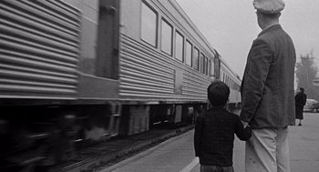 Movie still from “Murder by Contract” (1958), directed by Irving Lerner – A young boy standing on the side of a train platform; Medium shot, Low angle