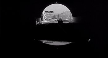 Movie still from “Murder by Contract” (1958), directed by Irving Lerner – A black and white photo of a tunnel with a car on the road; Extreme Wide shot, Low angle