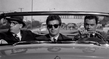 Movie still from “Murder by Contract” (1958), directed by Irving Lerner – A black and white photo of a man in a car; Close Up shot, Over the shoulder angle
