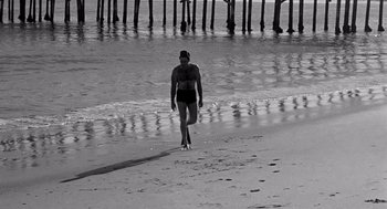 Movie still from “Murder by Contract” (1958), directed by Irving Lerner – A man walking on the beach near the water; Wide shot, Low angle