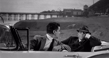 Movie still from “Murder by Contract” (1958), directed by Irving Lerner – Two men sitting in the back seat of a car; Medium shot, Over the shoulder angle