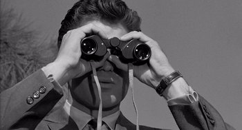 Movie still from “Murder by Contract” (1958), directed by Irving Lerner – A man looking through binoculars while wearing a suit; Close Up shot, High angle