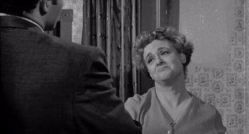 Movie still from “Murder by Contract” (1958), directed by Irving Lerner – An older woman is being hugged by an older man; Close Up shot, High angle