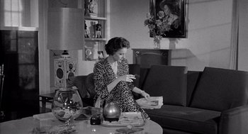 Movie still from “Murder by Contract” (1958), directed by Irving Lerner – A black and white photo of a woman looking at her cell phone; Medium shot, High angle