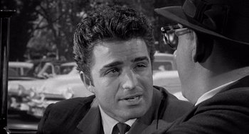 Movie still from “Murder by Contract” (1958), directed by Irving Lerner – A man wearing a suit and tie talking to another man wearing a hat; Close Up shot, Over the shoulder angle