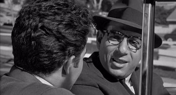 Movie still from “Murder by Contract” (1958), directed by Irving Lerner – A black and white photo of a man talking to another man; Close Up shot, Over the shoulder angle