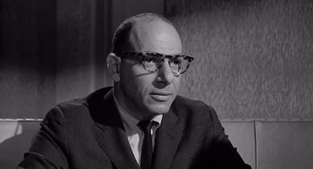 Movie still from “Murder by Contract” (1958), directed by Irving Lerner – An older man wearing a suit and glasses; Close Up shot, Low angle