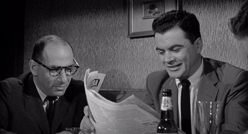 Movie still from “Murder by Contract” (1958), directed by Irving Lerner – Two men sitting at a table reading a newspaper; Close Up shot, Over the shoulder angle