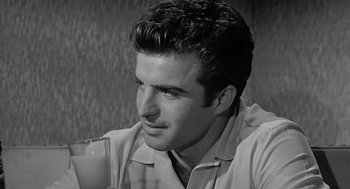 Movie still from “Murder by Contract” (1958), directed by Irving Lerner – A black and white photo of a man drinking a glass of milk; Close Up shot, Over the shoulder angle