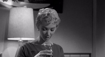 Movie still from “Murder by Contract” (1958), directed by Irving Lerner – A black and white photo of a woman holding a wine glass; Close Up shot, Low angle