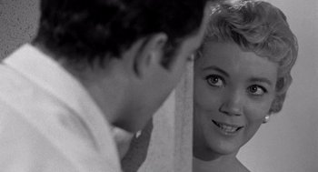 Movie still from “Murder by Contract” (1958), directed by Irving Lerner – A man and a woman looking at one another in a mirror; Close Up shot, Over the shoulder angle