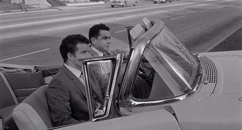Movie still from “Murder by Contract” (1958), directed by Irving Lerner – A couple of men sitting in the back seat of a car; Medium shot, Low angle