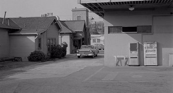 Movie still from “Murder by Contract” (1958), directed by Irving Lerner – An old car parked on the side of the street; Extreme Wide shot, High angle
