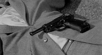 Movie still from “Murder by Contract” (1958), directed by Irving Lerner – A black and white photo of a gun laying on a jacket; Extreme Close Up shot, High angle