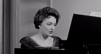 Movie still from “Murder by Contract” (1958), directed by Irving Lerner – A woman sitting at a piano in front of a mirror; Close Up shot, Low angle
