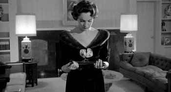 Movie still from “Murder by Contract” (1958), directed by Irving Lerner – A black and white photo of a woman in a black dress; Medium shot, Low angle