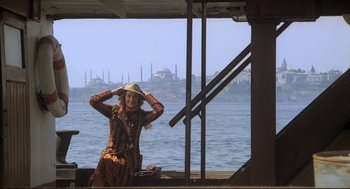 Movie still from “Murder on the Orient Express” (1974), directed by Sidney Lumet – A woman sitting in a boat on a body of water; Wide shot, Low angle