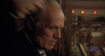 Movie still from “Murder on the Orient Express” (1974), directed by Sidney Lumet – An older man in a suit and tie looking to his left; Close Up shot, Over the shoulder angle