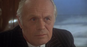 Movie still from “Murder on the Orient Express” (1974), directed by Sidney Lumet – An older man in a suit and tie looking at the camera; Close Up shot, Low angle