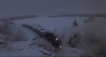 Movie still from “Murder on the Orient Express” (1974), directed by Sidney Lumet – A train traveling down tracks through a snow covered field; Extreme Wide shot, High angle