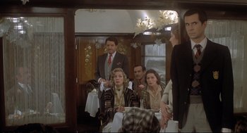 Movie still from “Murder on the Orient Express” (1974), directed by Sidney Lumet – A group of people sitting on a train; Medium shot, Over the shoulder angle