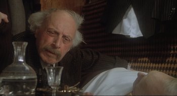 Movie still from “Murder on the Orient Express” (1974), directed by Sidney Lumet – An older man sitting at a table with a glass of wine; Close Up shot, Over the shoulder angle