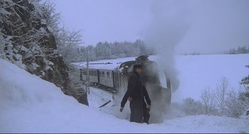 Movie still from “Murder on the Orient Express” (1974), directed by Sidney Lumet – A man standing in the snow next to a train on the tracks; Extreme Wide shot, High angle