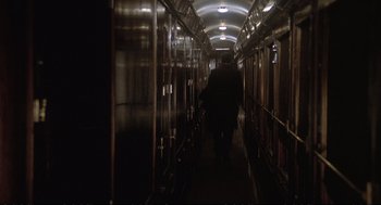 Movie still from “Murder on the Orient Express” (1974), directed by Sidney Lumet – A man walking down a long hallway in a train car; Wide shot, High angle